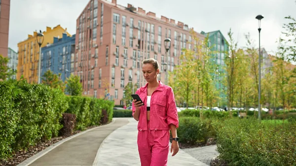 Şehir meydanında akıllı telefonlara bakan bir kız.