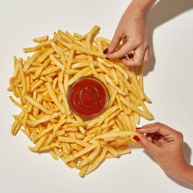 Eller soslu patates kızartmasını alıyor.