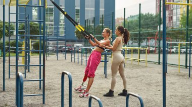 Kız, engelli arkadaşının sırt egzersizi yapmasına yardım eder