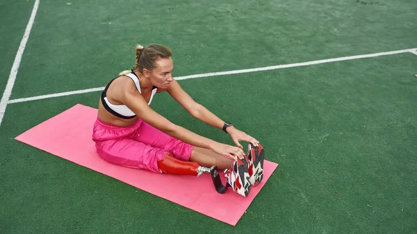Donna con disabilità gambe strette sul tappeto fitness — Foto Stock