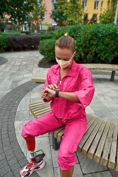 Meisje heeft handicap horloge op smartwatch op bank — Stockfoto