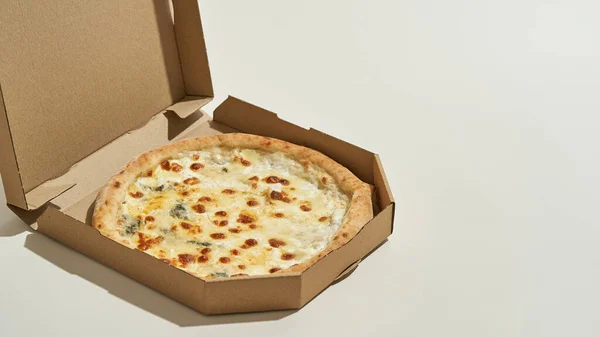 Pizza sabrosa en caja parcial de cartón abierta — Foto de Stock