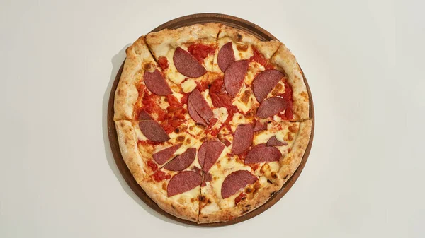 Corte deliciosa pizza de pepperoni en tablero de madera — Foto de Stock