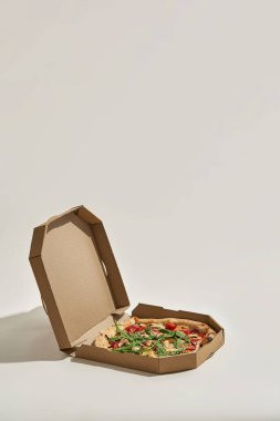 Karton kutuyu, taze ve iştah açıcı pizzayla aç.