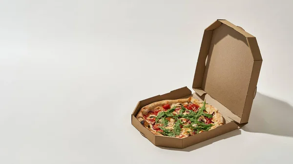 Caja de cartón abierta con pizza sobre fondo blanco — Foto de Stock