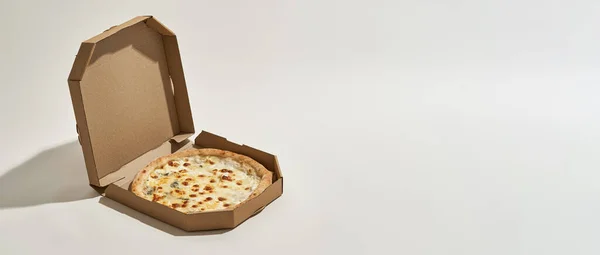 Caja de cartón abierta con cuatro pizzas de queso al horno — Foto de Stock