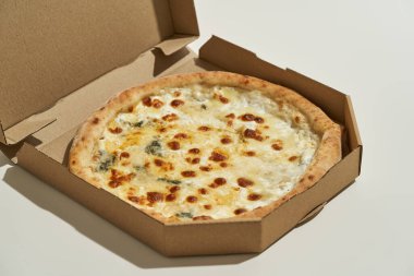 Karton kutuda peynirli dört peynirli pizza.