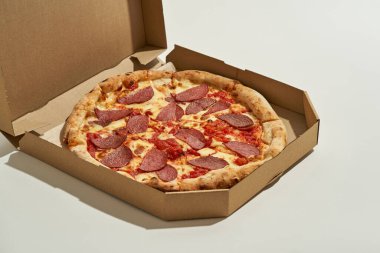 Kesilmiş karton kutuda Pepperoni pizza.