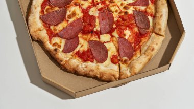 Açık karton kutunun içindeki pizzanın üst görüntüsü