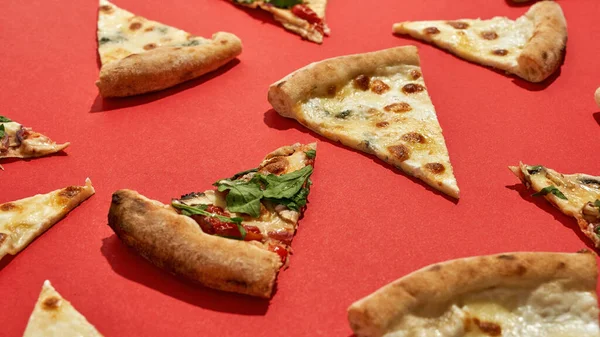 Imagen parcial de rebanadas de pizza sobre fondo rojo — Foto de Stock