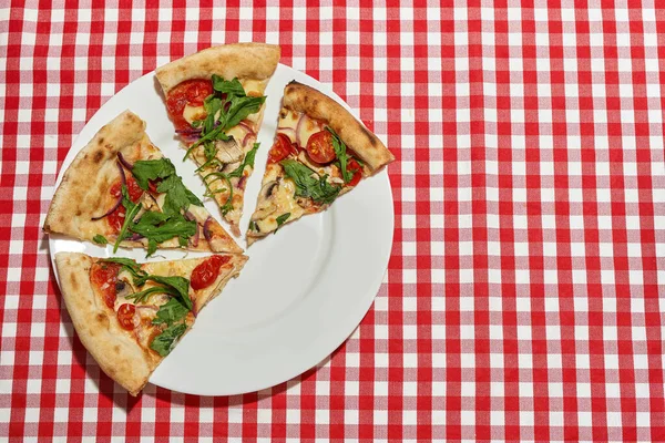 Vista superior de rebanadas de pizza cortadas en el plato en la mesa — Foto de Stock