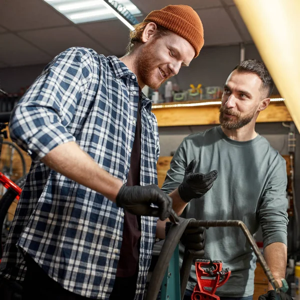 Mann spricht mit Kollegin über Klebepflaster auf Fahrradschlauch — Stockfoto