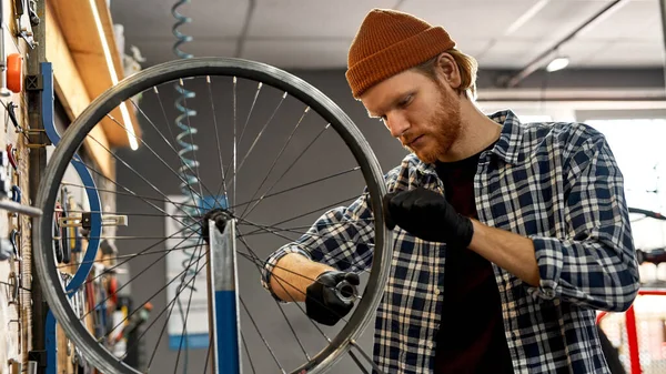 Mechanic check bike wheel spoke with spoke wrench