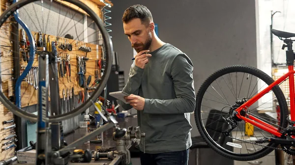 Przemyślany mechanik czyta lub pisze w notatniku — Zdjęcie stockowe