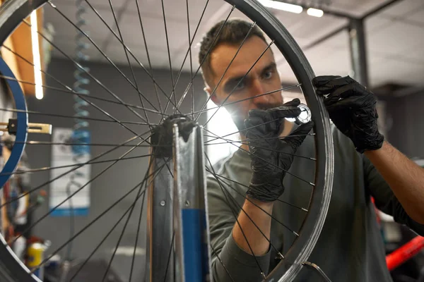 Focused cycling reapairman check bike wheel spoke