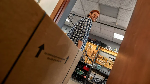 Yeni bisikletli bir adamın kutu taşıdığı alt manzara