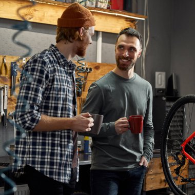 Tamirciler atölyede kahve içiyorlar.