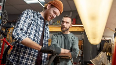 Erkek arkadaşına bakan bir adam bisiklet tüpünü tamir ediyor.