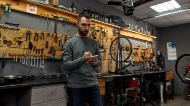 Bisikletçi iş yerindeki not defterine notlar yazar.