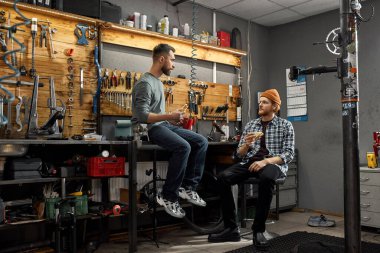 Erkekler atölyede çay ve sandviçle öğle yemeği yer.