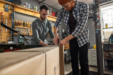 Erkek işçiler karton kutuyu yeni bisikletle açarlar.