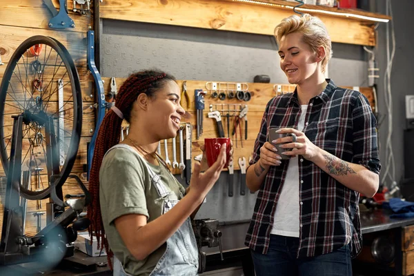 Frauen trinken Tee und reden in Fahrradwerkstatt — Stockfoto
