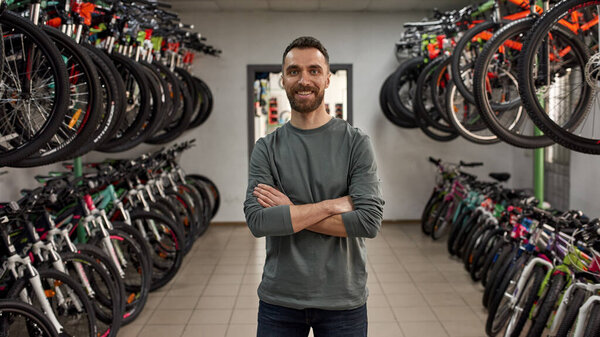 Front view of bearded male seller in bike shop