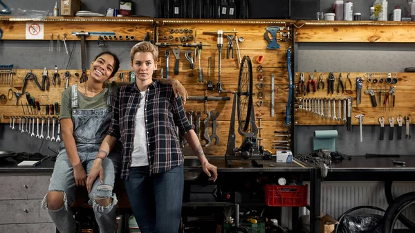 Dos jóvenes técnicas de bicicleta en el taller — Foto de Stock
