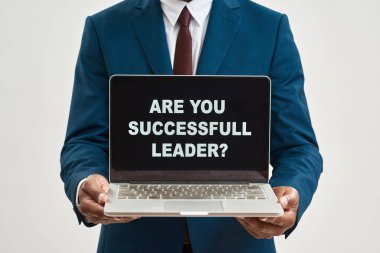 Elinde dizüstü bilgisayarla gezen siyahi işadamlarından oluşan başarılı bir lider sorusu. Adam resmi giyiniyor. Modern başarılı erkek yaşam tarzı. Beyaz arka plan. Stüdyo çekimi. Boşluğu kopyala