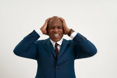 Migreni olan yorgun siyah girişimci elleriyle kafasına dokunuyor. Resmi kıyafet giyen kel bir yetişkin. Modern başarılı erkek yaşam tarzı kavramı. Beyaz arka planda izole edilmiş. Stüdyo çekimi. Boşluğu kopyala