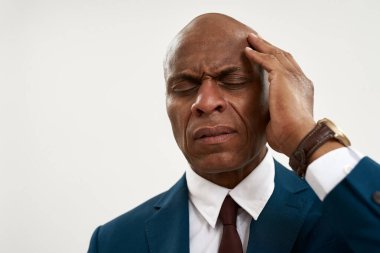 Başı ağrıyan yorgun Afrikalı Amerikalı iş adamının bir kısmı. Takım elbiseli kel bir yetişkin. Modern başarılı erkek yaşam tarzı. Beyaz arka planda izole edilmiş. Stüdyo çekimi. Boşluğu kopyala