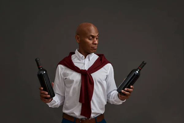 Odaklanmış Siyah Şarap Üreticisi Şarap Garsonu Elinde Şarap Şişesine Bakıyor — Stok fotoğraf
