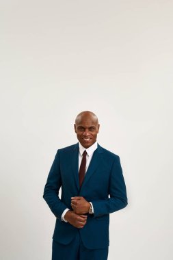 Afro-Amerikan gülümseyen iş adamının kameraya bakışının görüntüsü. Takım elbiseli kel bir yetişkin. Modern başarılı erkek yaşam tarzı kavramı. Beyaz arka planda izole edilmiş. Stüdyo çekimi. Boşluğu kopyala