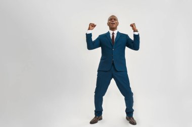 Afrikalı Amerikan CEO 'su ya da menajeri zaferini kutluyor. Takım elbiseli kel bir yetişkin. Modern başarılı erkek yaşam tarzı kavramı. Beyaz arka planda izole edilmiş. Stüdyo çekimi. Boşluğu kopyala