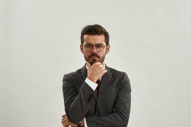 Kafkasyalı düşünceli iş adamının kameraya bakışının ön görüntüsü. Resmi kıyafet ve gözlük takan sakallı adam. Modern başarılı erkek yaşam tarzı. Beyaz arka planda izole edilmiş. Stüdyo çekimi. Boşluğu kopyala