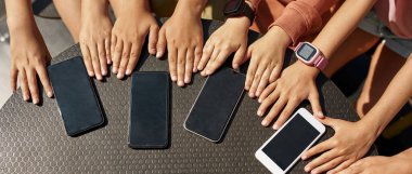 Çocukların ellerinin ve akıllı telefonlarının açık havada salıncakta sallanışının kısmi üst görüntüsü. Modern dijital nesil alfa 'nın kızları ve erkekleri. Gadget bağımlılığı. Arkadaşlık. Çocukluk yaşam tarzı. Güneşli bir gün
