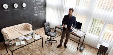 Kafkas bilişim işadamı, elinde kağıt belgeler ve kupalarla büroda video görüşmesi yapıyor. Çevrimiçi toplantı ve iletişim. İş stratejisi, geliştirme, tanıtım ve satış