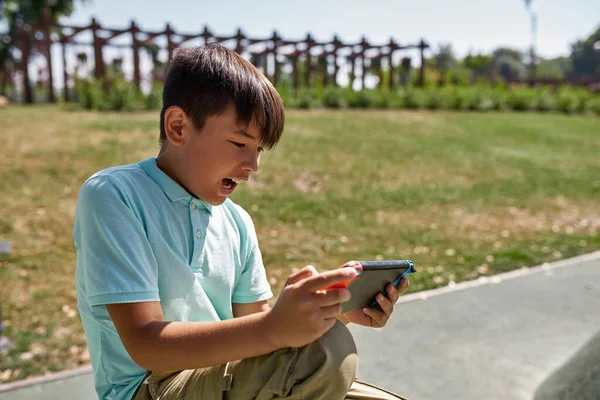 야외의 게임기에서 벌리고 비디오 게임을 흥분된 디지털 알파의 남자아이 현대의 — 스톡 사진
