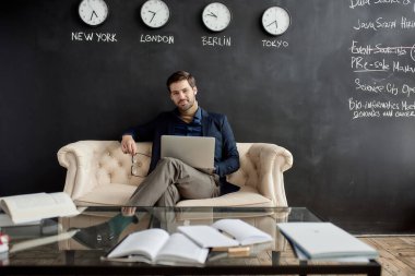 Ofisteki koltukta kameraya bakan modern başarılı beyaz bilişim işadamı ya da dizüstü bilgisayarlı yönetici. İş stratejisi, geliştirme, tanıtım, satış, yüksek teknoloji şirketlerinin pazarlanması