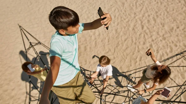 Pohled Shora Multiraciální Děti Hledající Mobilní Připojení Lezecké Síti Dětském — Stock fotografie