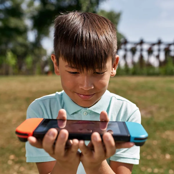 Niño Multiétnico Enfocado Sosteniendo Consola Juegos Las Manos Aire Libre —  Fotos de Stock