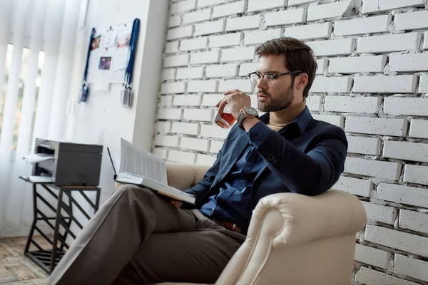 Analista Negocios Caucásica Concentrada Leyendo Libro Bebiendo Brandy Vidrio Sillón — Foto de Stock