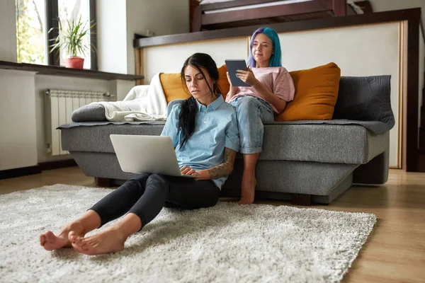 Menina Que Navega Tablet Digital Sofá Enquanto Sua Namorada Usando — Fotografia de Stock