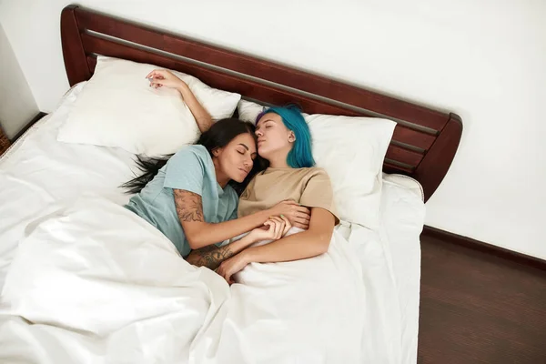 俯瞰年轻漂亮的高加索女同性恋夫妇躺在床上 睡在床上的毛毯下 同性恋关系 家庭生活方式 清晨时分 现代公寓宽敞的卧室 — 图库照片