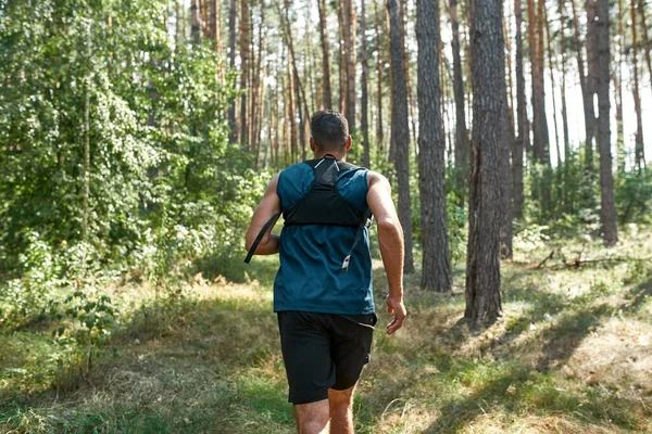 선수가 숲에서 심장외과 훈련을 동안달리거나 조깅하는 모습을 뒤에서 수있다 신고검은 — 스톡 사진