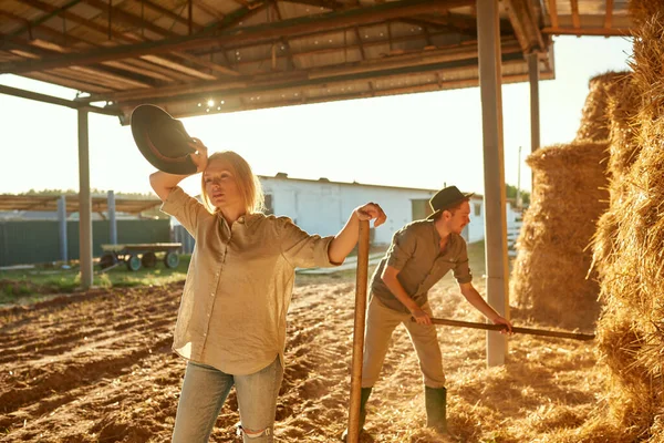 Man Collecting Hay Bale Pitchfork While His Tired Girlfriend Wiping — Stock Photo, Image