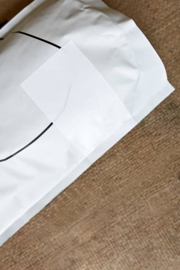 Taze organik kahve çekirdekleri ile tekstil çuvalında uzanan yakın çekim kahve paketinin kısmi üst görüntüsü. Başarılı küçük işletmeler. Fabrika veya kahve dükkanında kahve yapımı ve üretimi