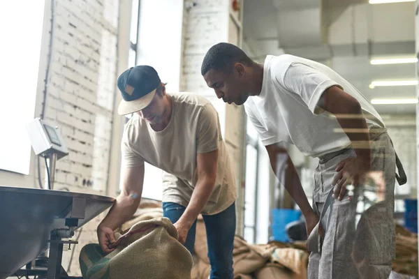 Black Male Worker Looking His Colleague Opening Sack Coffee Beans — Fotografia de Stock