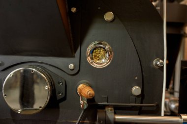 Fabrikanın içinde yeşil fasulye bulunan endüstriyel kahve kızartma makinesinin bir kısmı. Kahve yapma ve üretme kavramı. Küçük bir iş. Modern otomatik üretim ekipmanları. Kimse.