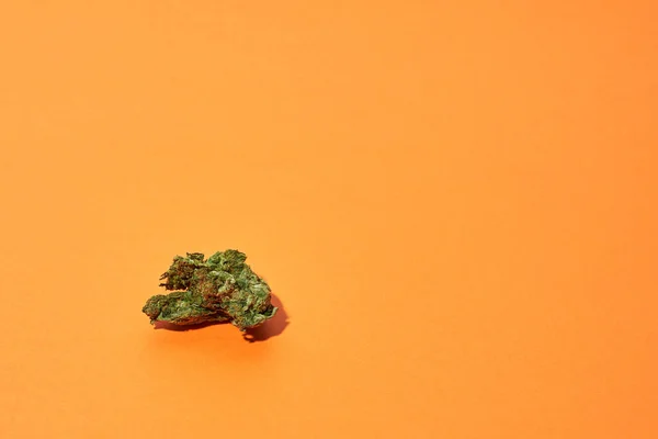 Groene Droge Gemalen Marihuana Knop Geïsoleerd Oranje Achtergrond Lichte Drug — Stockfoto
